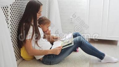 年轻的母亲为她的小女儿读书。